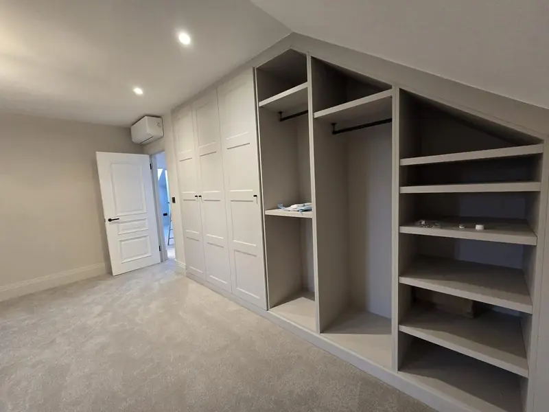 Bedroom with built-in wardrobes, open shelving and a wall-mounted air conditioning unit